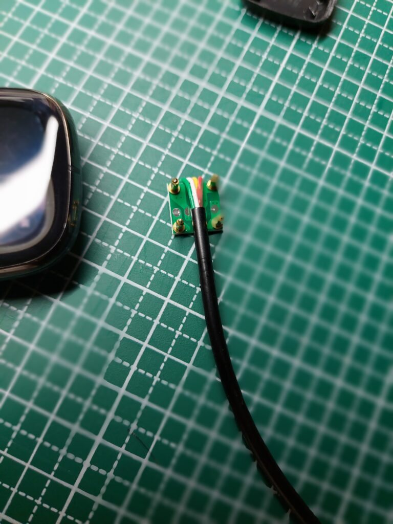 Fitbitの充電プラグを分解した様子。ピンが戻らない様子がわかる、同時に修理がほぼできないことも理解できる。